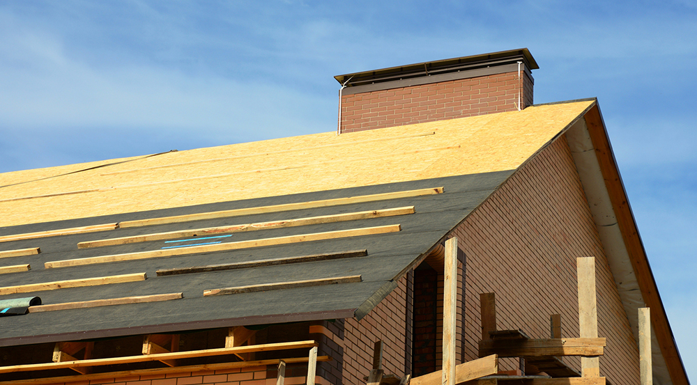 Roof underlayment being installed on a roof